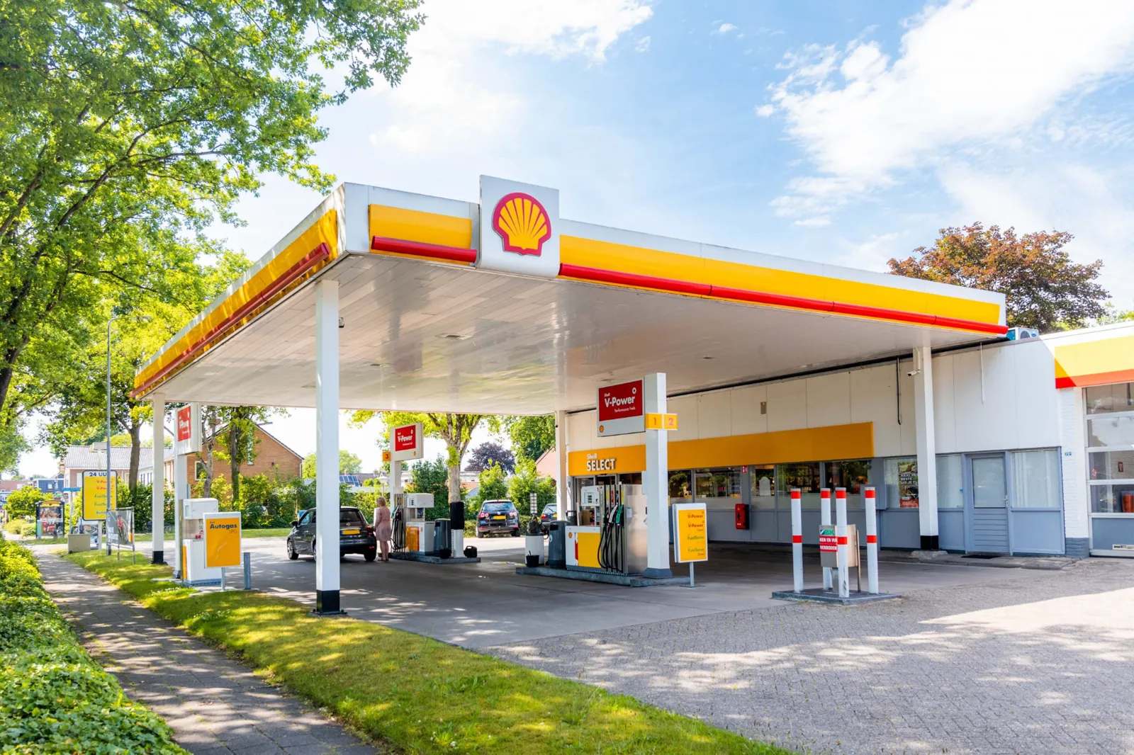 Onbemand tankstation met luifel, pompen en shop bij daglicht